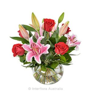 Arrangement of Lilies and Roses in a Glass Fishbowl